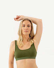 Load image into Gallery viewer, A woman is standing with one arm over her head and wearing an amrêve organic pima cotton green bralette.