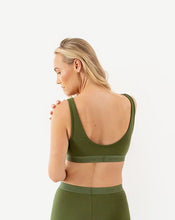 Load image into Gallery viewer, A woman is wearing the amrêve organic cotton bralette in green. She is looking over her shoulder to show the scoop neck back.