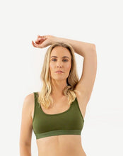 Load image into Gallery viewer, A woman is standing with one arm over her head and wearing an amrêve organic pima cotton green bralette.
